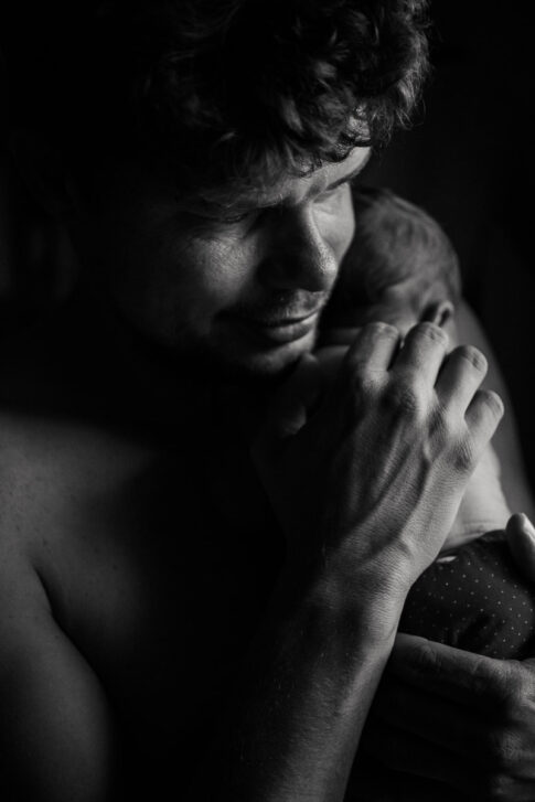Vater mit Neugeborenen auf Arm nach Hausgeburt , dokumentiert von Der Geburtsfotografin Lisa von Rekows