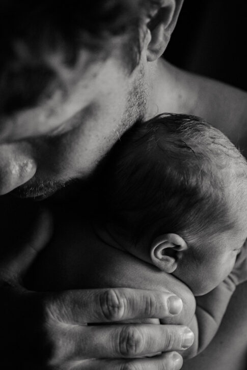 Vater mit Neugeborenen auf Arm nach Hausgeburt , dokumentiert von Der Geburtsfotografin Lisa von Rekows