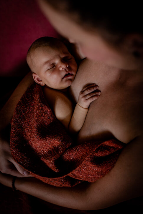 Neugeborenen Shooting Baby auf Brust der Mama nach dem Stillen. Satt und glücklich.