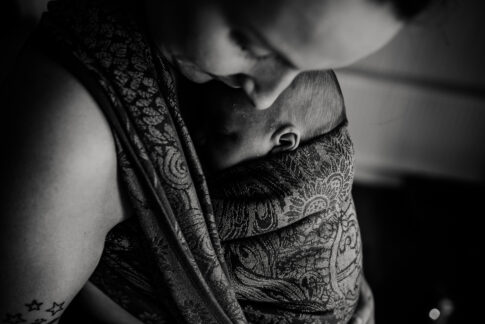Innige Aufnahme einer Mutter mit Baby im Tragetuch in schwarzweiß