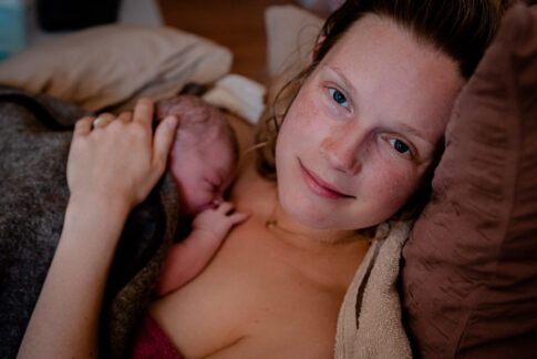 Die wunderschöne Mutter lächelt glücklich in die Kamera. Geburtsfotografie Celle