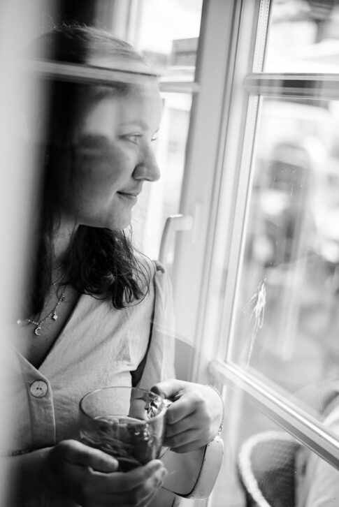 Frau schaut aus Cafefenster bei einem Businessshooting in Celle