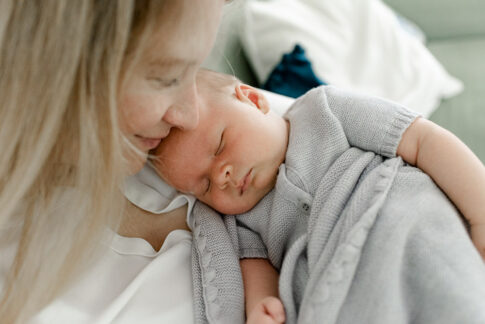Säugling liegt schlafend im Arm der Mutter während eines Babyshooting in Celle, Hannover, Braunschweig