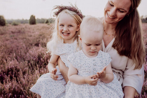 Mutter und Töchter auf Heidewiese bei Fotoshooting mit Haarkranz