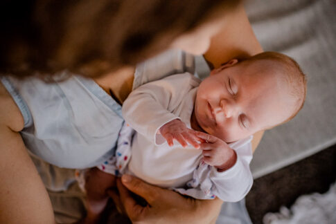 Mama hält Neugeborenes auf Arm bei Newbornshooting in Celle