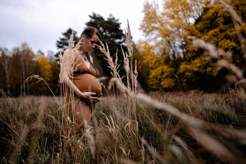 schwangere Frau bei Babybauchshooting in herbstlicher Stimmung auf Wiese bei Celle