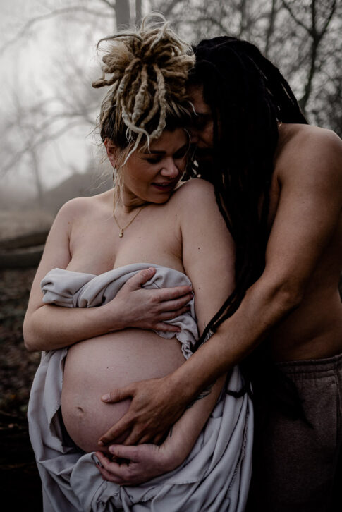 verliebtes Paar, die Frau ist schwanger stehen am Wasser im Nebel für Babybauchfotos in Hannover