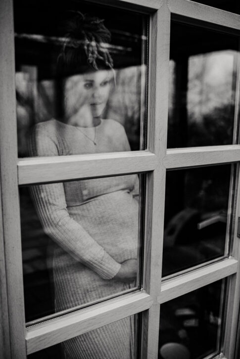 schwangere Frau steht an Fenster bei Babybauchshooting in Hannover