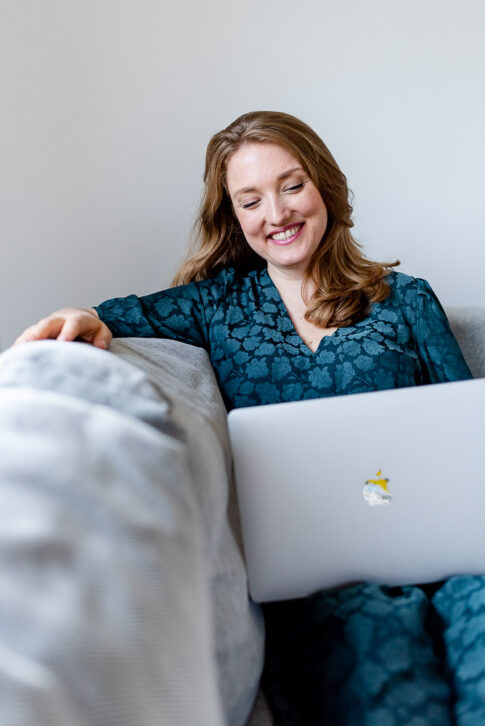 Frau lächelt bei ihrer Arbeit am Laptop, während einees Businessshootings bei Celle von Lisa von Rekowski Fotografie