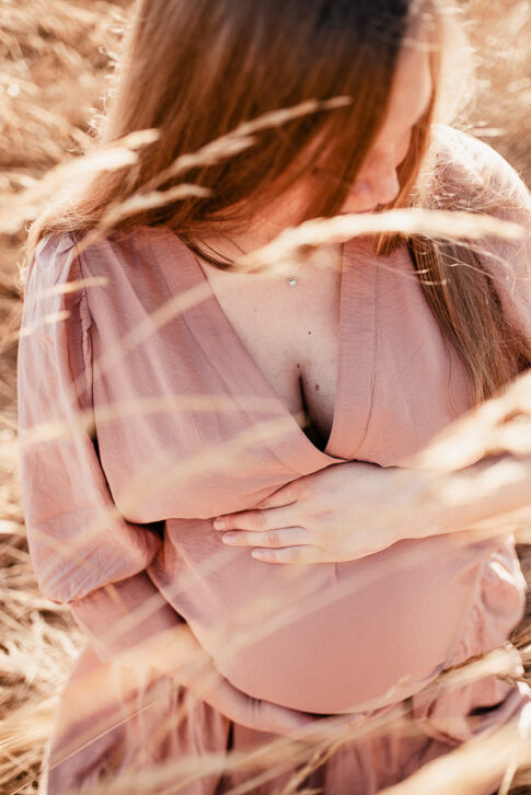 schwangere Frau bei Fotoshooting auf Wiese